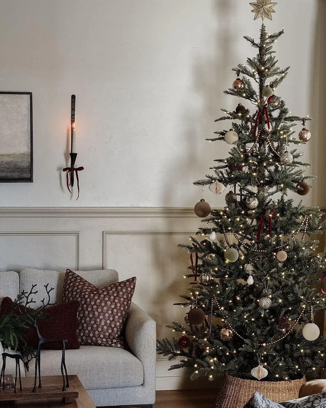 Beige Christmas tree with brown and gold ornaments in a cozy living room
