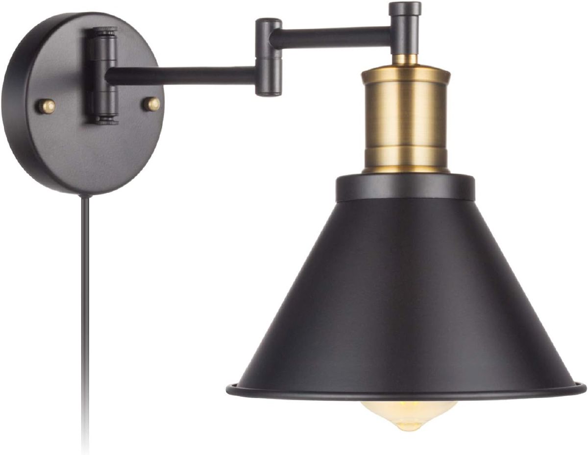 Bronze and black swing-arm wall sconce with a fabric shade and plug-in cord, mounted beside a bed for accent lighting