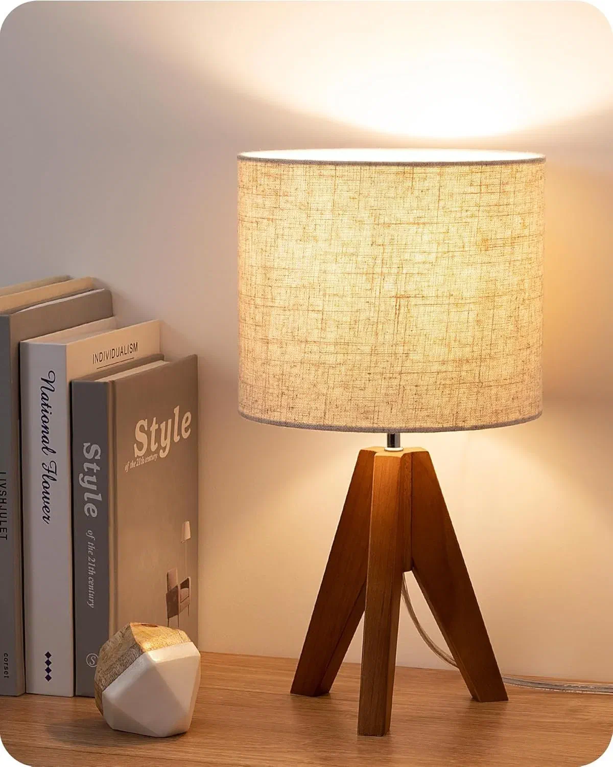 Affordable wood tripod bedside lamp with beige linen shade in mid-century modern bedroom