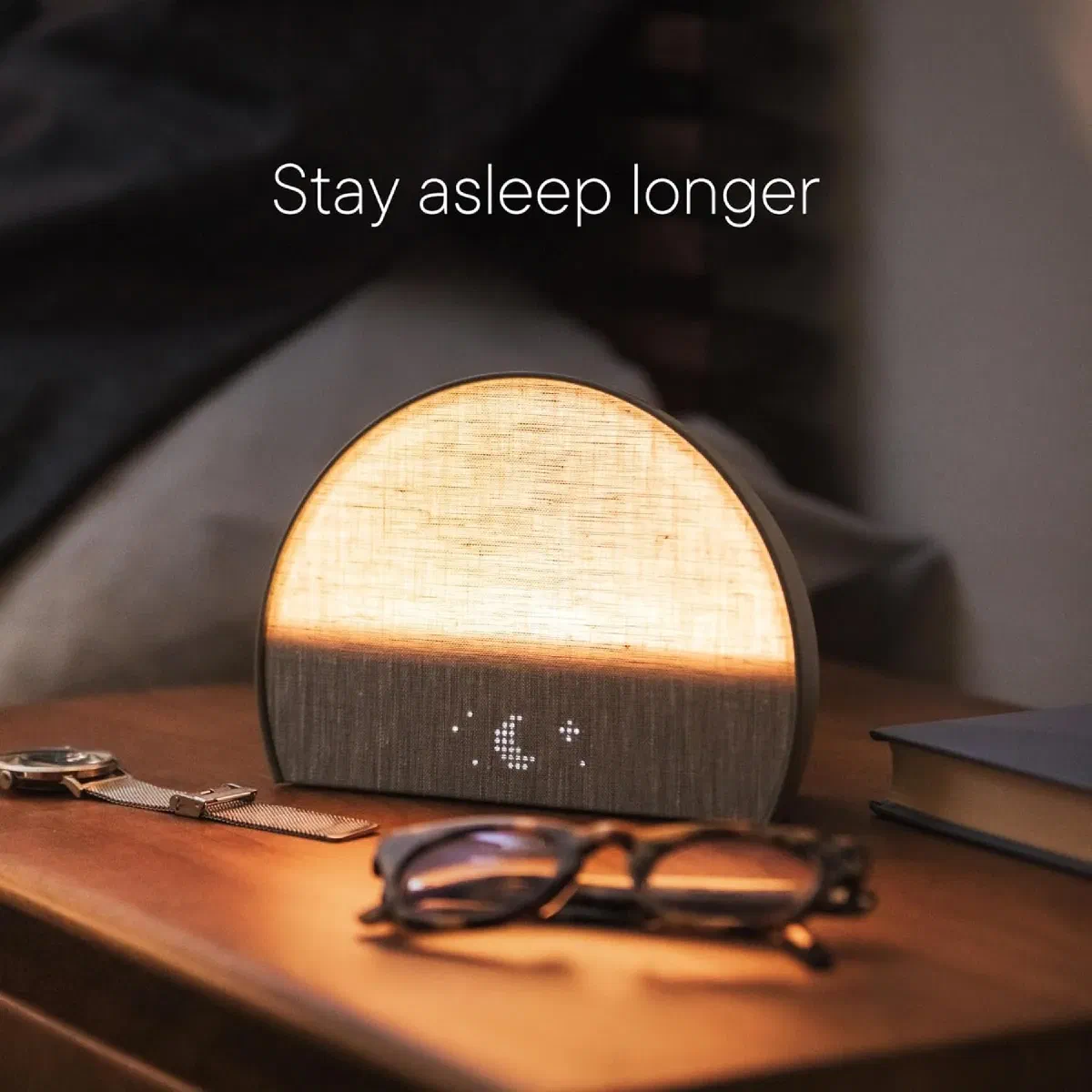 Hatch Restore 2 smart sleep assistant with customizable sunrise alarm and sound machine on nightstand