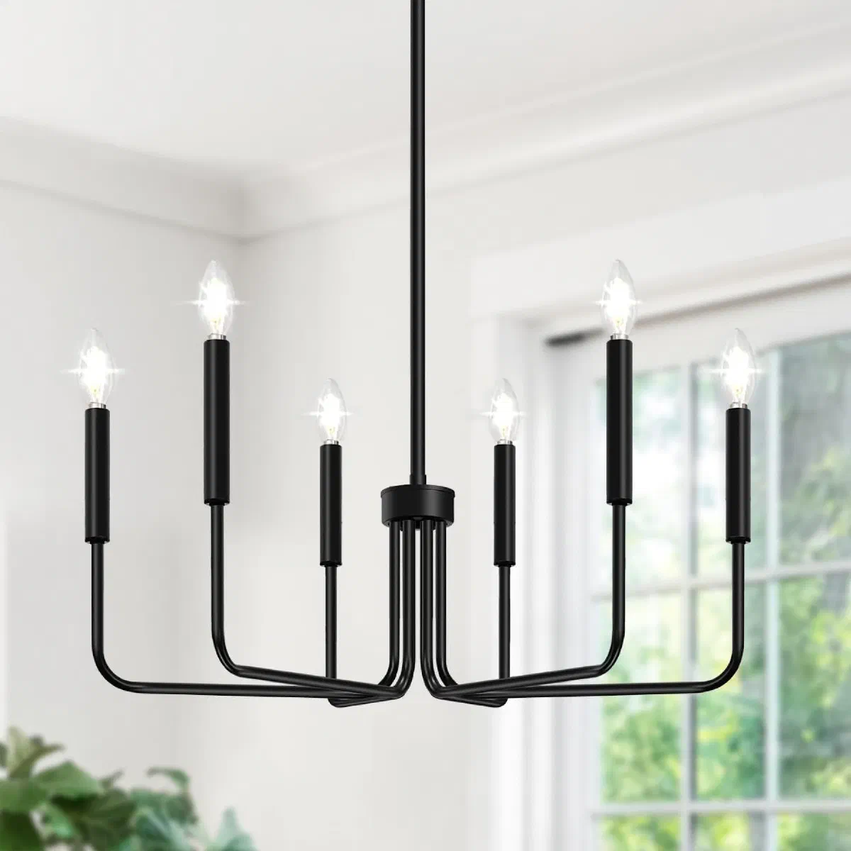 Matte black 6-light farmhouse candle chandelier with adjustable splicing rods, hanging over a dining table