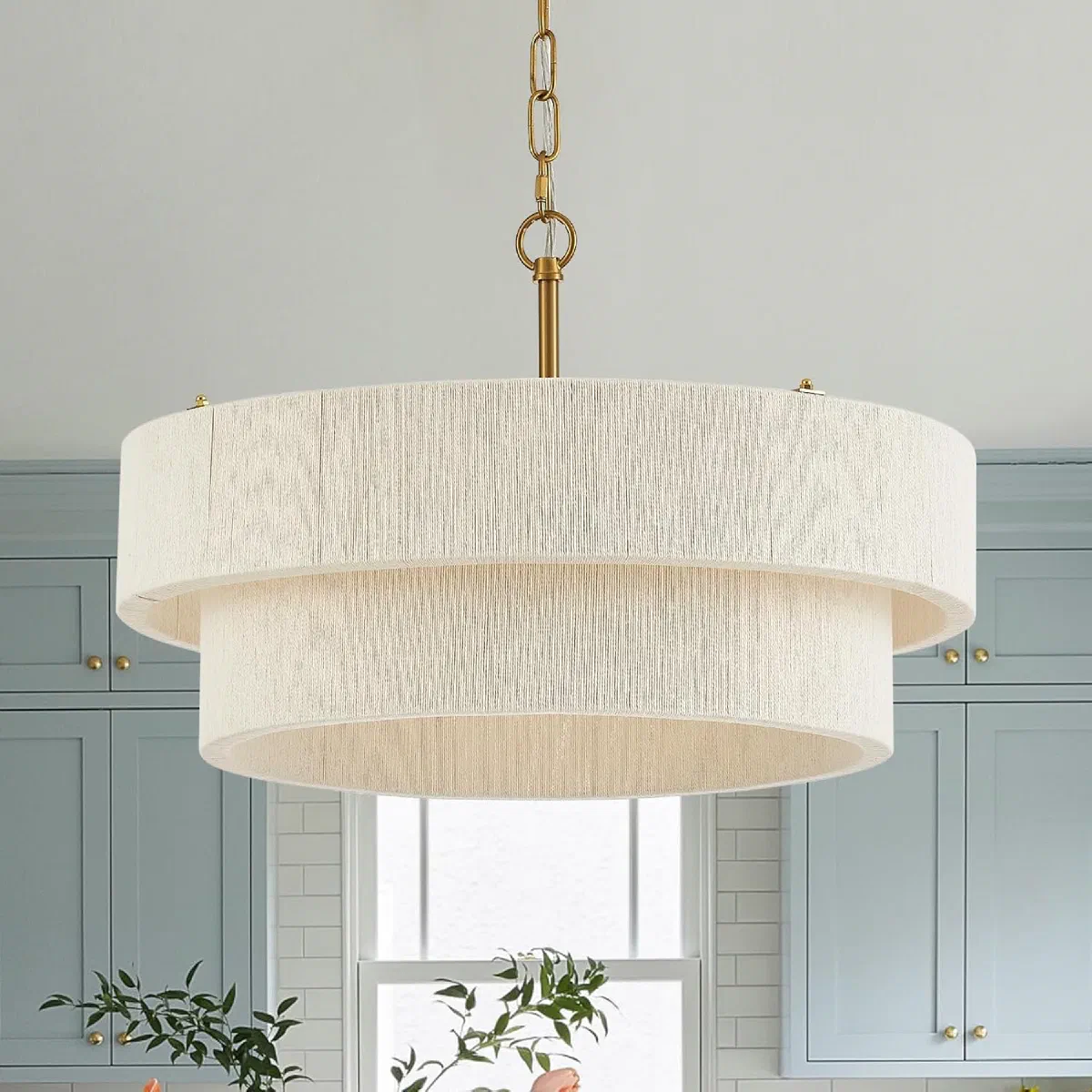 Two-tier hand-woven rattan boho pendant light with brass hardware, hanging over a dining table