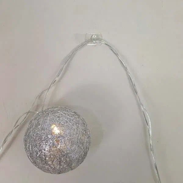 Easy fairy light hanging with command strips, no nails needed, silver ball light on white wall