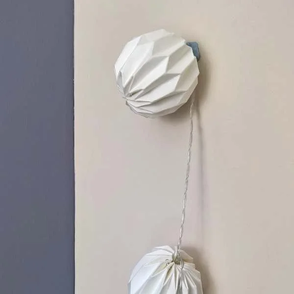 Easy fairy light hanging with blue tack, white paper light on wall