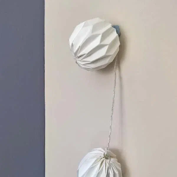 Easy fairy light hanging with blue tack, white paper light on wall