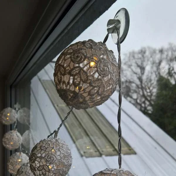 Hanging fairy lights on a window with a wire sucker