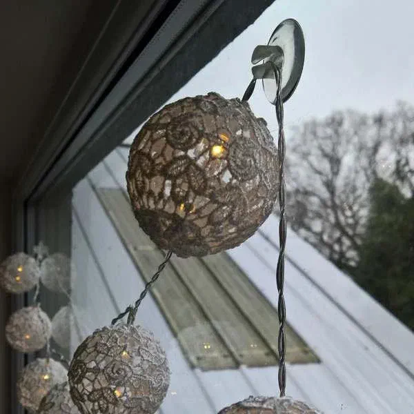 Hanging fairy lights on a window with a wire sucker