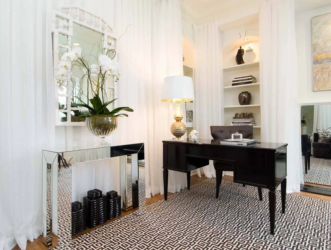 Home office with mirrors and light colors, showing how to make a room brighter. White curtains, mirror, and light walls reflect light.