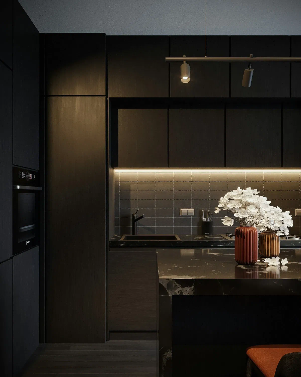 Modern dark kitchen with under-cabinet LED lighting, black marble countertop, and minimal track lighting above the island.
